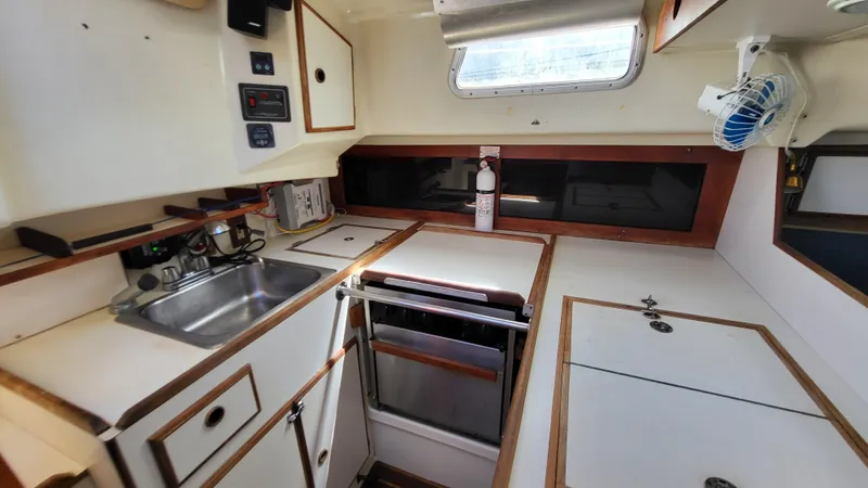 Slide: The Image of 1979 Pearson 365 Sloop kitchen interior with sink, stove, and storage cabinets. - 18