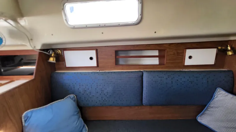 Slide: The Image of Interior of 1979 Pearson 365 Sloop with blue cushions and wooden cabinetry. - 24