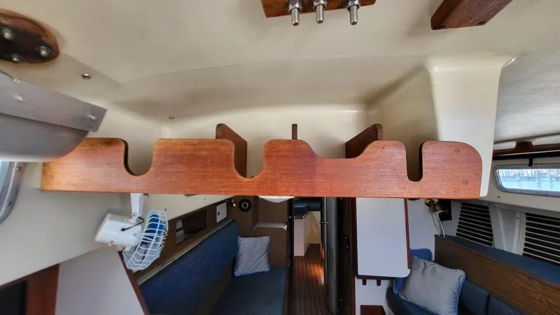 Slide: The Image of Interior of 1979 Pearson 365 Sloop sailboat with wooden storage rack and seating area. - 27