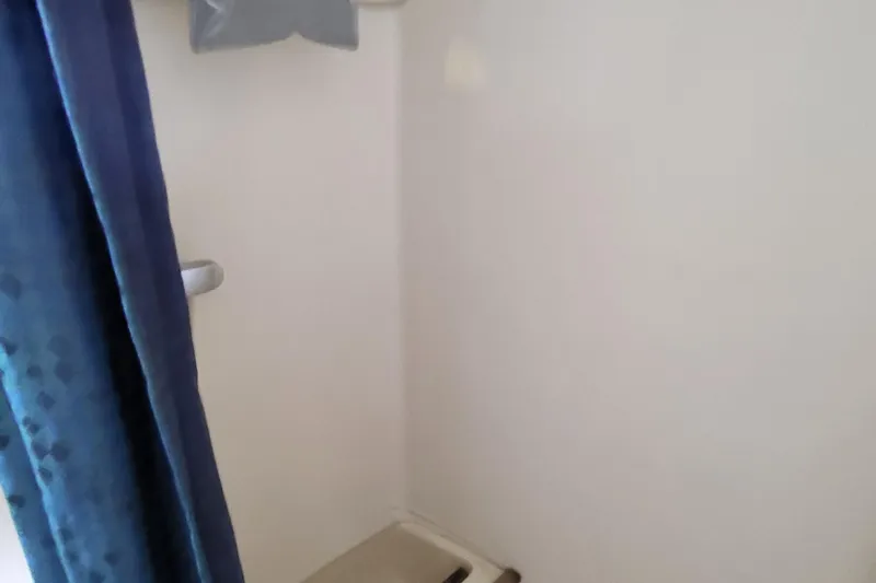 Slide: The Image of Interior of 1979 Pearson 365 Sloop, featuring a compact shower area with blue curtain. - 33