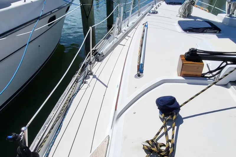 Slide: The Image of 1979 Pearson 365 Sloop deck with ropes and winch, docked beside another boat. - 6