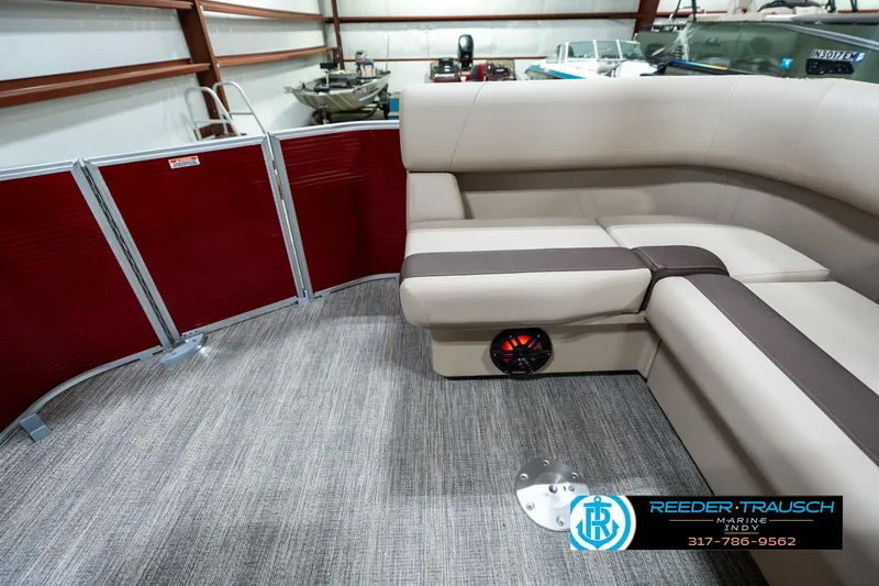 Slide: The Image of 2025 Bennington 21 SLS pontoon boat interior with beige seating and red paneling. - 14