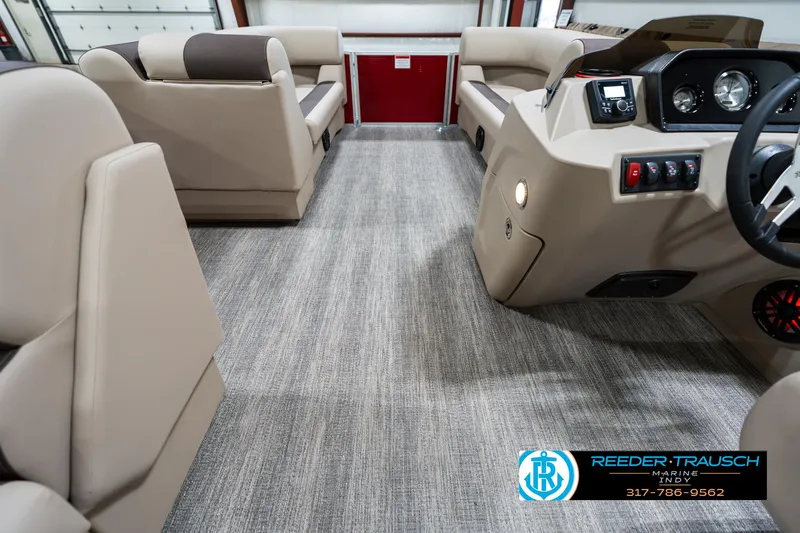 Slide: The Image of 2025 Bennington 21 SLS boat interior with beige seating and modern dashboard. - 16