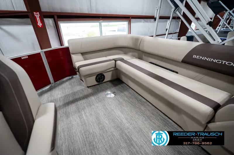 Slide: The Image of 2025 Bennington 21 SLS boat interior with beige seating and carpeted flooring. - 21