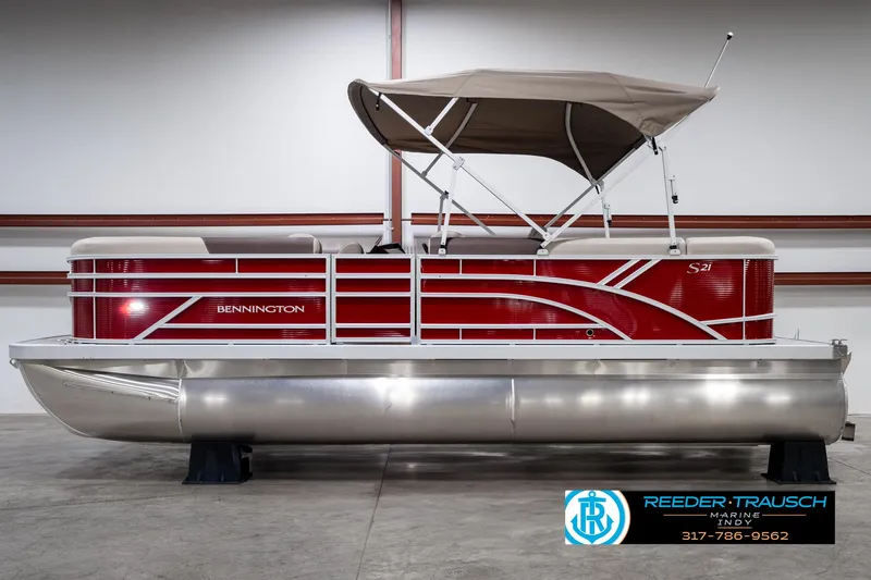 Slide: The Image of 2025 Bennington 21 SLS pontoon boat with red exterior and canopy in showroom. - 5
