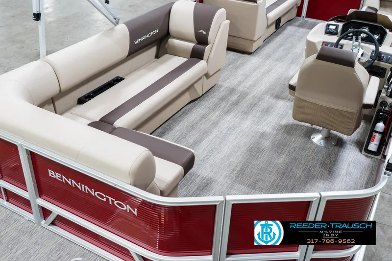 Slide: The Image of 2025 Bennington 21 SLS pontoon boat interior with beige seating and steering console. - 9