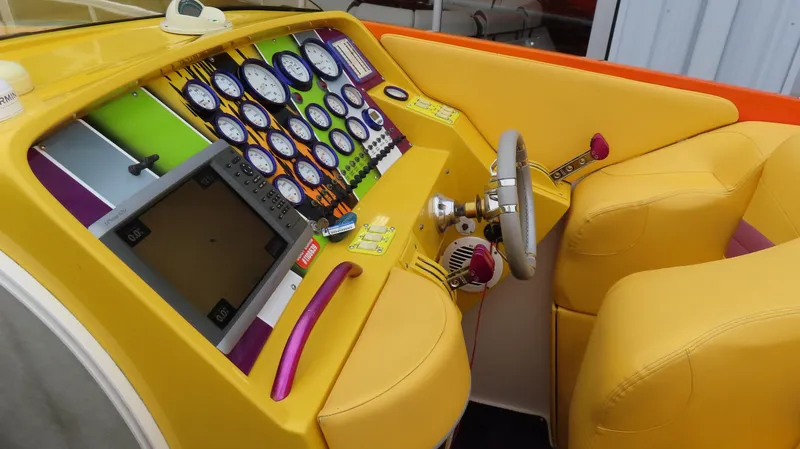 Slide: The Image of Cockpit of a 2001 Outerlimits 42 Legacy boat with vibrant yellow and orange interior. - 15