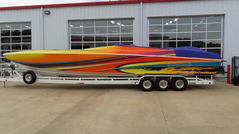 Slide: The Image of Colorful 2001 Outerlimits 42 Legacy speedboat on trailer, parked outside a garage. - 29