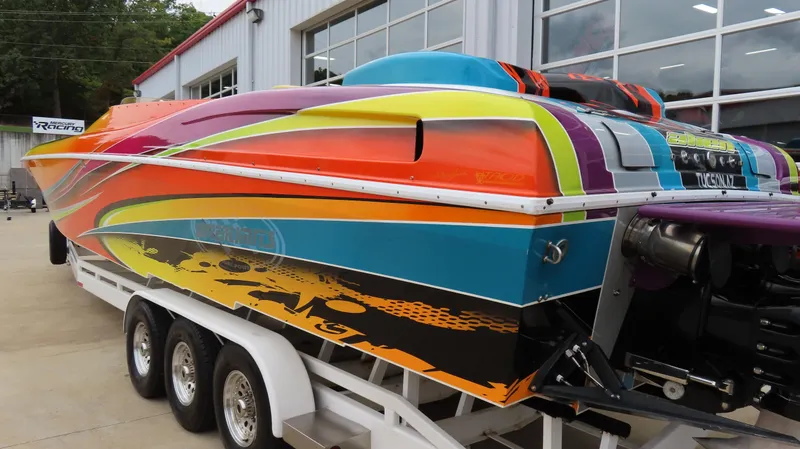 Slide: The Image of Colorful 2001 Outerlimits 42 Legacy speedboat on trailer, vibrant design, parked near a building. - 4