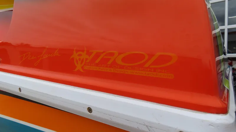 Slide: The Image of 2001 Outerlimits 42 Legacy boat with vibrant orange and white design details. - 8