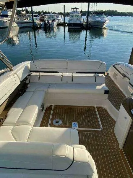 Slide: The Image of 2016 Formula 350 Sun Sport boat interior with white seating and wooden deck at marina. - 26