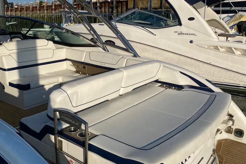 Slide: The Image of 2016 Formula 350 Sun Sport boat with white seating, docked alongside other boats. - 36