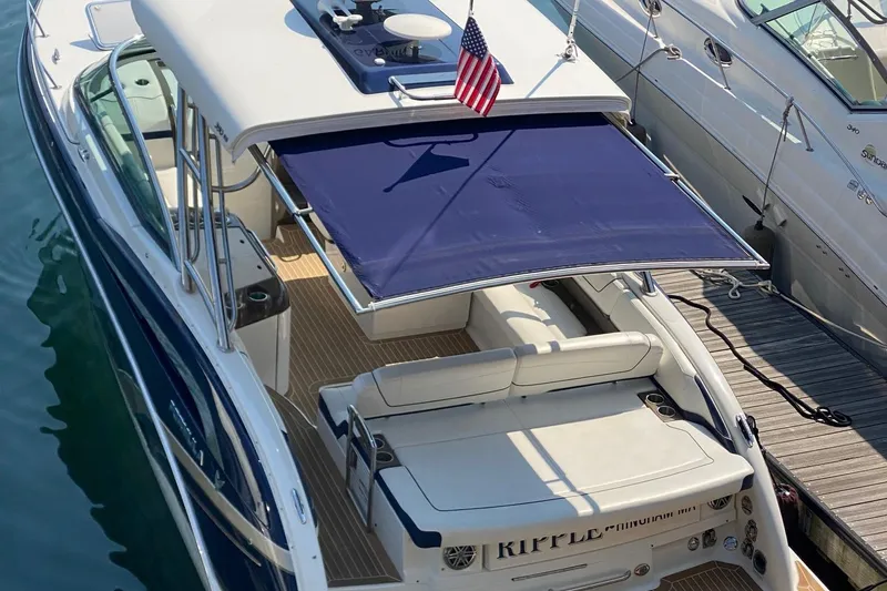 Slide: The Image of 2016 Formula 350 Sun Sport boat docked with blue canopy and American flag. - 7