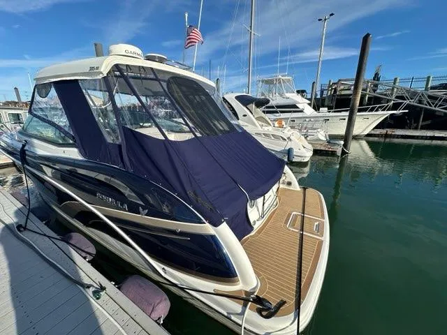 Slide: The Image of 2016 Formula 350 Sun Sport boat docked in marina, blue canopy, American flag. - 8