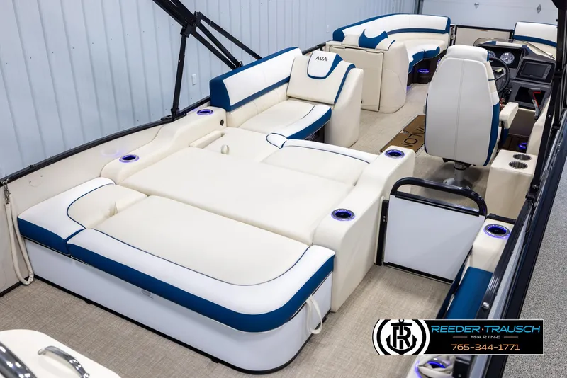Slide: The Image of 2025 Avalon Catalina VRB boat interior with luxurious white and blue seating, cup holders, and steering console. - 12