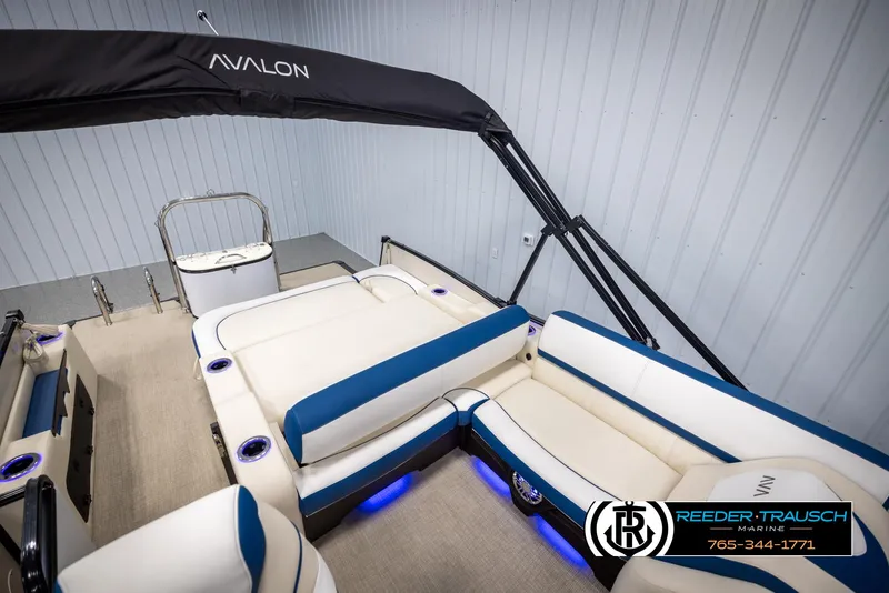 Slide: The Image of 2025 Avalon Catalina VRB boat interior with blue and white seating, under-seat lighting, and canopy. - 25