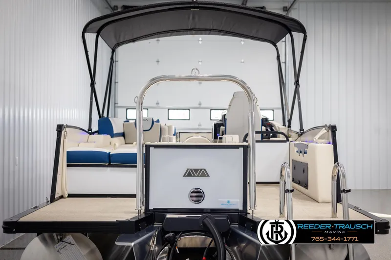 Slide: The Image of 2025 Avalon Catalina VRB pontoon boat in showroom, featuring blue and white seating. - 7