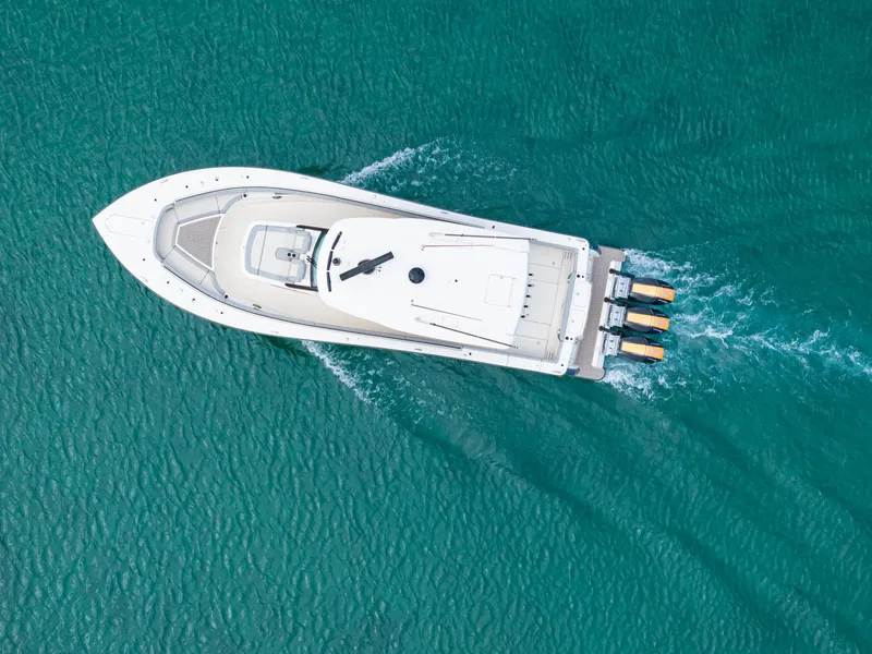 Slide: The Image of Aerial view of 2023 Scout 425 LXF boat cruising on turquoise water. - 15