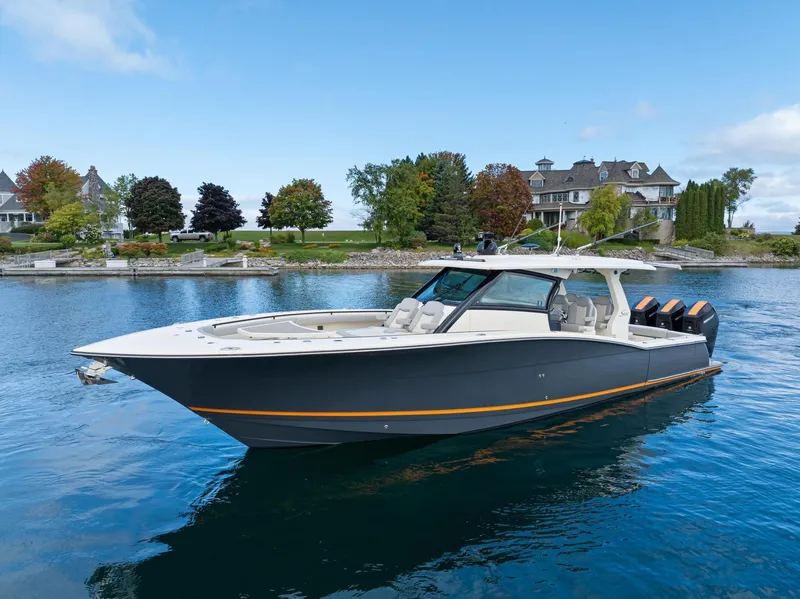 Slide: The Image of 2023 Scout 425 LXF boat on serene water with scenic background. - 18