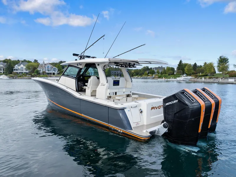 Slide: The Image of 2023 Scout 425 LXF boat with triple Mercury engines on a calm lake. - 19