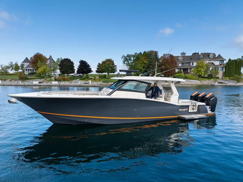 Slide: The Image of 2023 Scout 425 LXF boat on calm water near luxury homes. - 29