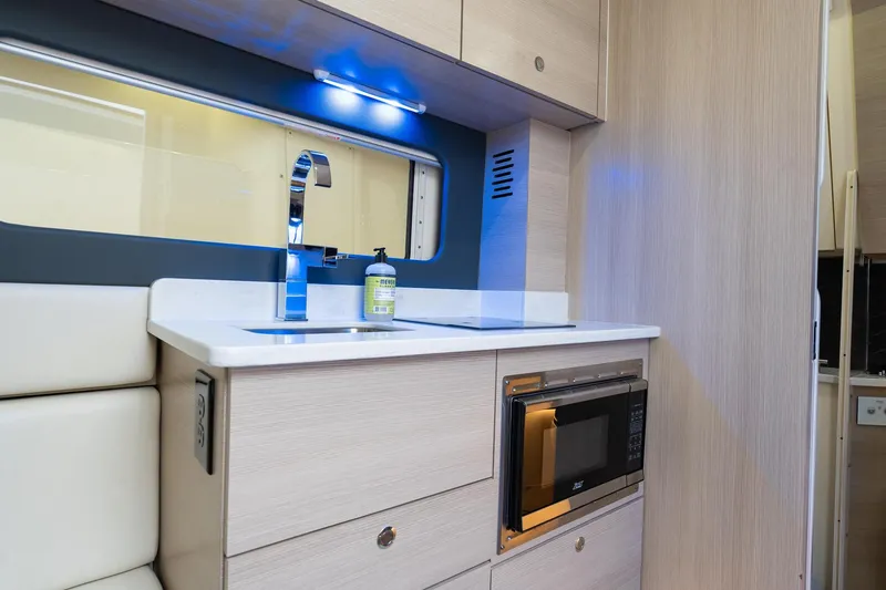 Slide: The Image of 2023 Scout 425 LXF interior kitchen with sink, microwave, and modern cabinetry. - 37