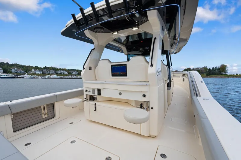 Slide: The Image of 2023 Scout 425 LXF boat interior with seating and control panel on a sunny day. - 47