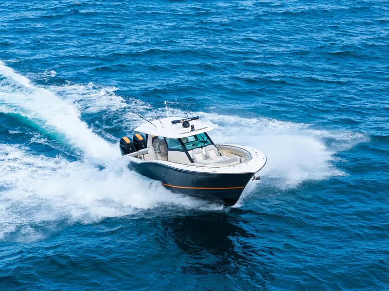 Slide: The Image of 2023 Scout 425 LXF boat cruising on open blue ocean waters. - 9