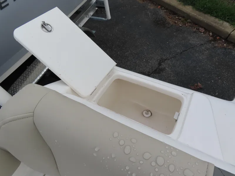 Slide: The Image of Key West 219 FS 2025 boat storage compartment with open lid and water droplets. - 29