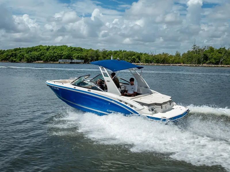 Slide: The Image of 2017 Chaparral 227 SSX boat cruising on a scenic waterway under a cloudy sky. - 19