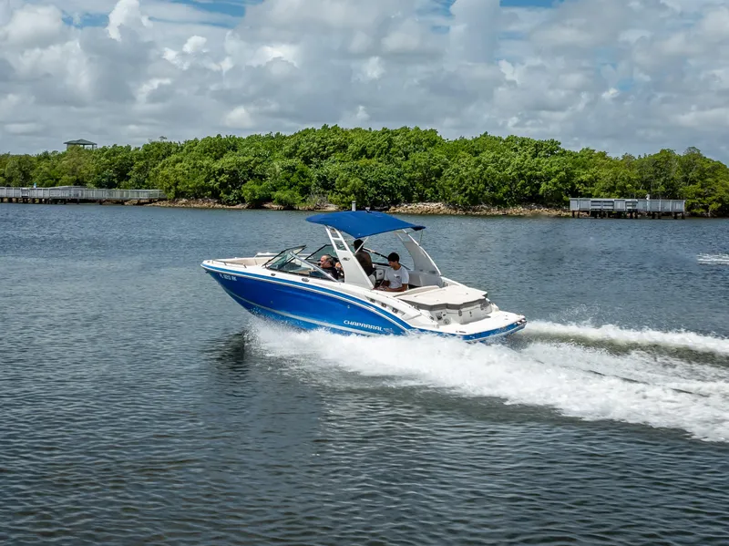 Slide: The Image of 2017 Chaparral 227 SSX boat cruising on a scenic lake with lush greenery. - 20