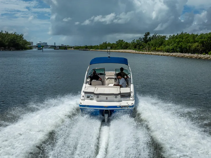Slide: The Image of 2017 Chaparral 227 SSX boat cruising on a scenic waterway under cloudy skies. - 22
