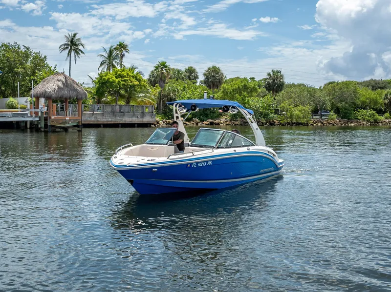 Slide: The Image of 2017 Chaparral 227 SSX boat cruising on a sunny day near lush greenery. - 3