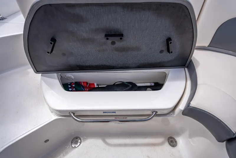 Slide: The Image of Open storage compartment in 2017 Chaparral 227 SSX boat, showing interior space and items. - 32