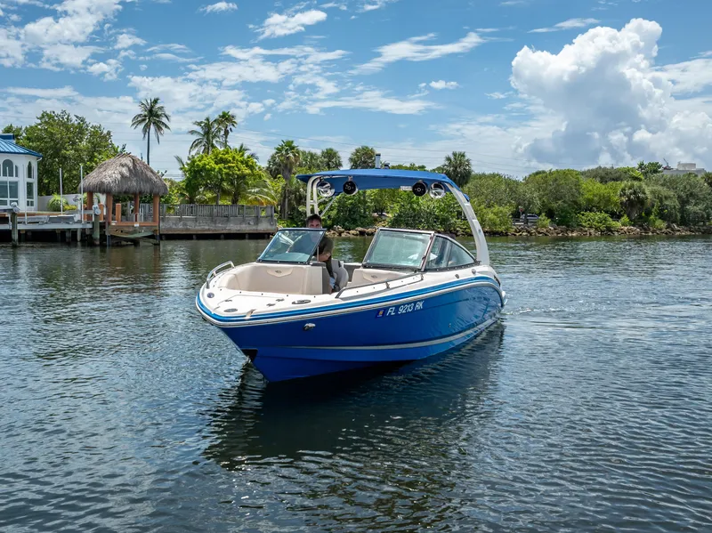 Slide: The Image of 2017 Chaparral 227 SSX boat cruising on a sunny day near lush greenery and waterfront homes. - 4
