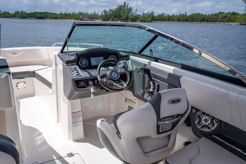 Slide: The Image of 2017 Chaparral 227 SSX boat interior with steering wheel and dashboard, near water. - 43