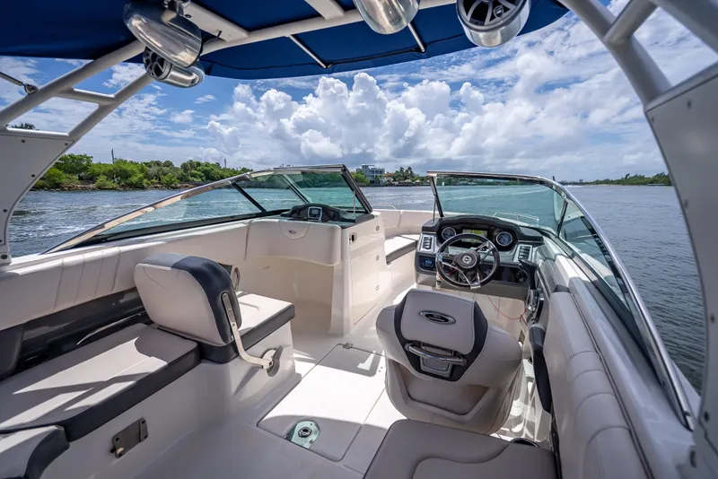 Slide: The Image of 2017 Chaparral 227 SSX boat interior with steering wheel, seating, and blue canopy. - 44