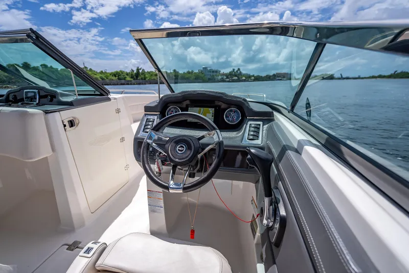 Slide: The Image of 2017 Chaparral 227 SSX boat interior with steering wheel, dashboard, and water view. - 49