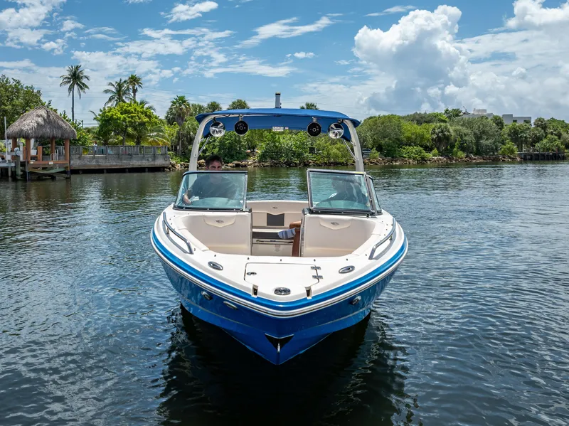 Slide: The Image of 2017 Chaparral 227 SSX boat on a sunny day, surrounded by lush greenery. - 5