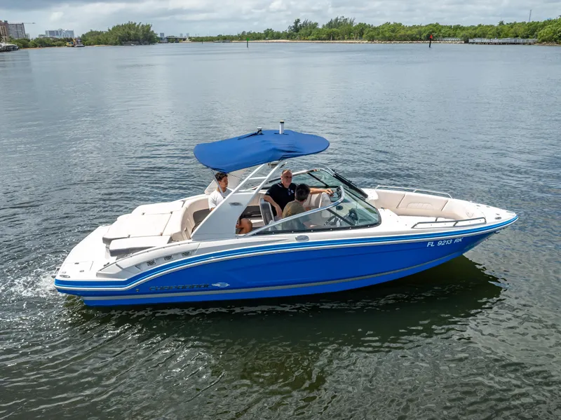 Slide: The Image of 2017 Chaparral 227 SSX boat with blue canopy cruising on calm water. - 8