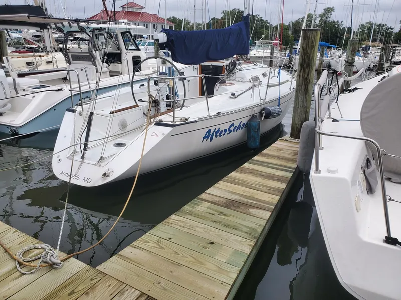 Slide: The Image of 2001 Schock 35 sailboat docked at a marina, surrounded by other boats. - 1