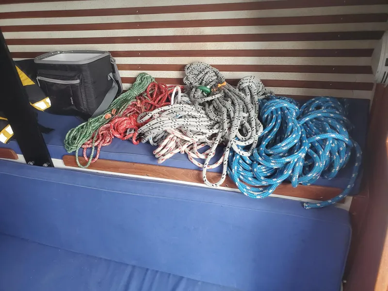 Slide: The Image of Interior cabin of a 2001 Schock 35 sailboat with blue bedding and wooden accents. - 14