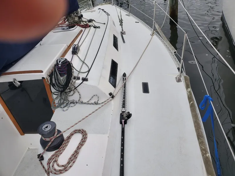 Slide: The Image of Sailboat deck view of a 2001 Schock 35, docked alongside other boats. - 5