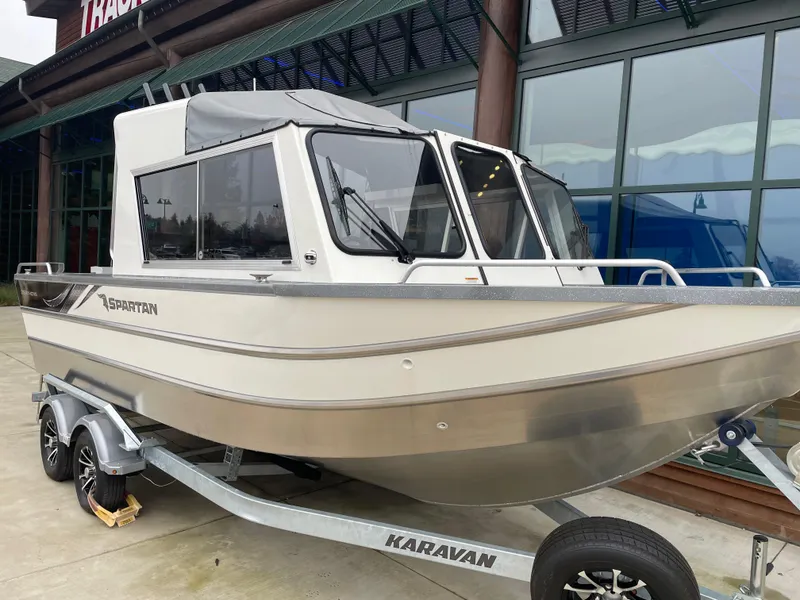 Slide: The Image of 2024 Spartan 215 Athens boat on Karavan trailer, displayed outdoors. - 1