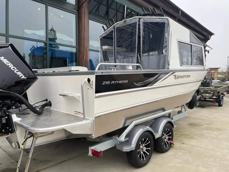 Slide: The Image of 2024 Spartan 215 Athens boat on trailer, featuring a Mercury outboard motor. - 2