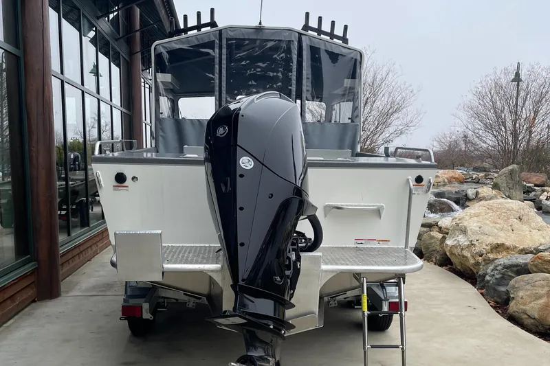 Slide: The Image of 2024 Spartan 215 Athens boat with powerful outboard motor, parked outdoors. - 3