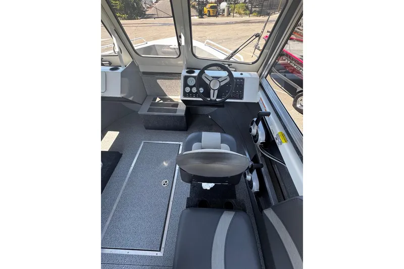Slide: The Image of 2024 Spartan 215 Athens boat interior with steering wheel and seating. - 9