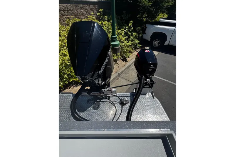 Slide: The Image of 2024 Spartan 215 Athens boat with dual Mercury outboard motors in a parking lot setting. - 11