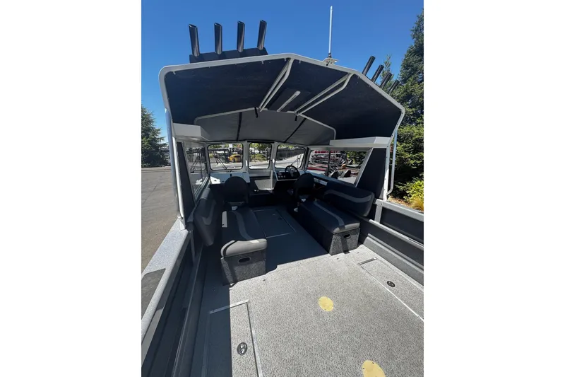 Slide: The Image of 2024 Spartan 215 Athens boat interior with seating and rod holders, under a clear blue sky. - 13