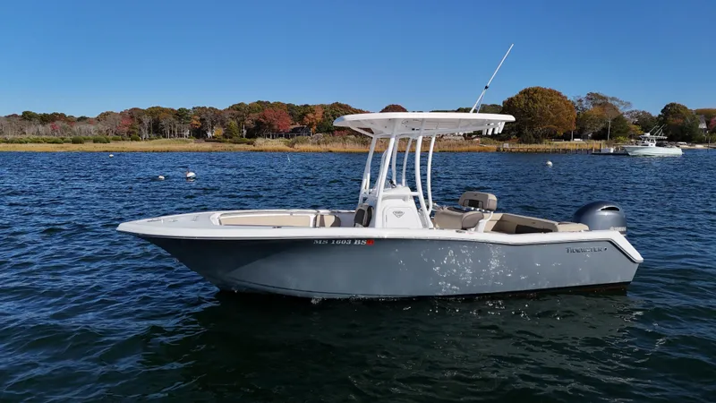 Slide: The Image of 2019 Tidewater 220 LXF boat on calm water, clear sky background. - 1